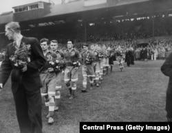 Dynamo Moscow players walk out onto the pitch at Stamford Bridge carrying bouquets for their Chelsea opponents.