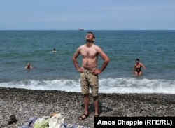 Denis Gorbachyov, a tourist from the Russian town of Saratov, soaks up the sun on a beach in Batumi amid reports of danger for Russians in Georgia.