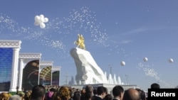 People gather as the statue is unveiled in Turkmenistan's capital, Ashgabat.