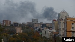 Smoke rises above buildings after a warehouse was hit by Russian shelling in Donetsk, Russian-controlled Ukraine, on October 21.