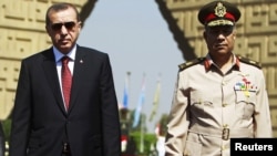 Turkish Prime Minister Recep Tayyip Erdogan (left) pays a visit to the tomb of the late former President Anwar al-Sadat's in Cairo with Egyptian army commander General Hassan al-Roweny.