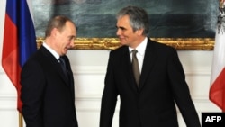 Russian Prime Minister Vladimir Putin (left) is welcomed by Austrian Chancellor Werner Faymann before their meeting in Vienna.