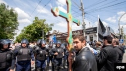 An Orthodox believer with a cross takes part in a protest against a rally organized by the LGBT community for human rights and equality in Chisinau on May 21.