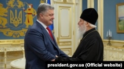 Ukrainian President Petro Poroshenko (left) meets with Patriarch Filaret, head of the Ukrainian Orthodox Church of the Kyiv Patriarchate, in Kyiv on October 11.