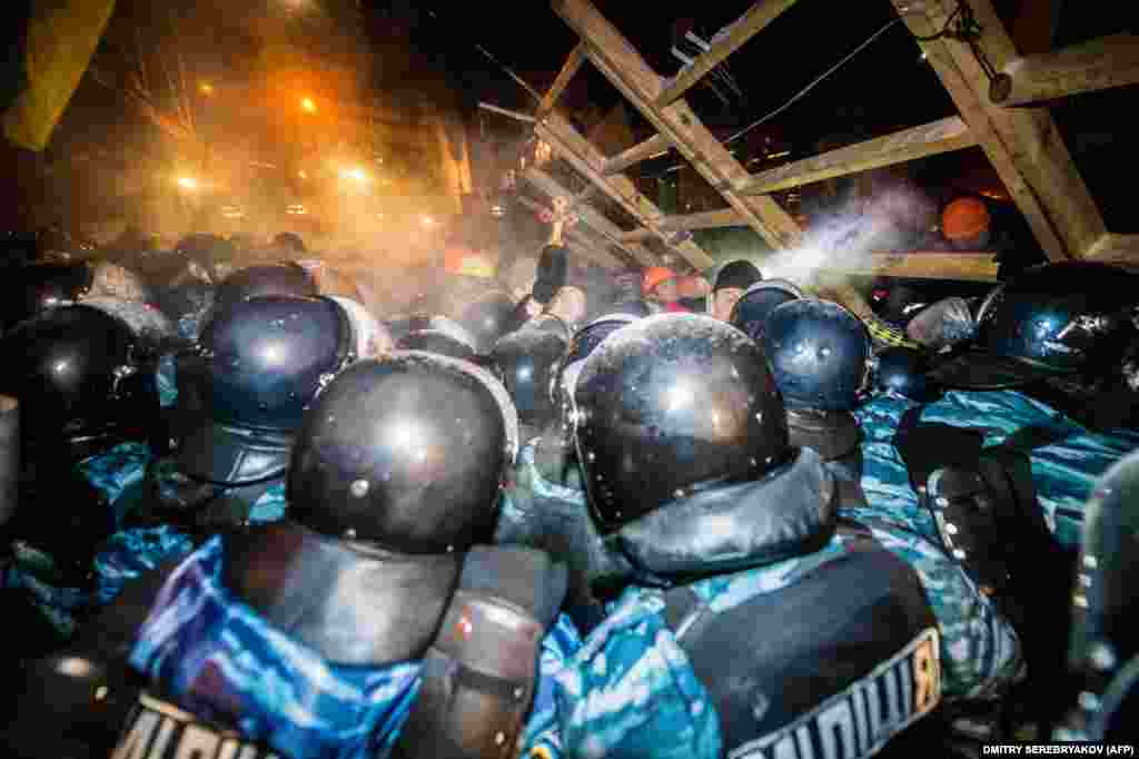 Riot police storm a barricade held by protesters on Independence Square in Kyiv late on December 11, 2013. The demonstrators defiantly refused to leave and resisted the police in a tense standoff. Berkut riot police and Interior Ministry special forces moved against the protesters at around 2&nbsp;a.m. in a move that prompted U.S. Secretary of State John Kerry to express &quot;disgust&quot; over the crackdown.