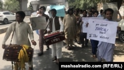 Afghan and Pakistani musicians play music and sing during a protest in Peshawar on May 30.