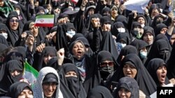 Iranians wave the national flag as they take part in a state-sponsored rally in Tehran on September 23. 