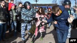 Police intervene against two young protesters at an anticorruption rally in central Moscow on March 26. 