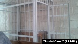 A barred cell in a Tajik courtroom