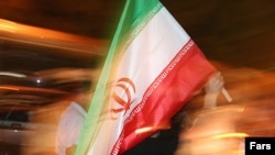 A supporter of Iranian President Mahmud Ahmadinejad waves the national flag in Tehran at a rally ahead of the vote.