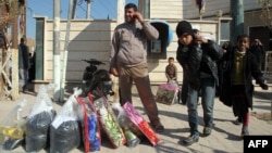 Iraqis who fled violence in Fallujah collect aid supplies in Karbala on January 9.