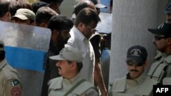 Former Pakistani President Pervez Musharraf (center) was escorted by soldiers as he arrived in court in Islamabad on April 12.