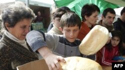 Refugees receiving bread at a camp for displaced persons outside Gori