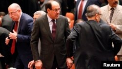 Iraqi Prime Minister Nuri al-Maliki (center) attends a session of parliament in Baghdad on July 1.