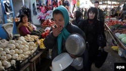 A woman peddles metal basins at a street market in Sukhumi, Abkhazia.