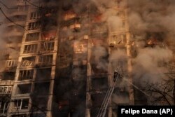 Ukrainian firefighters work at a bombed apartment building in Kyiv on March 15.