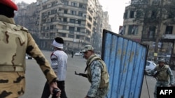 Soldiers escort the few remaining protesters away from Tahrir Square.