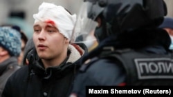 A pro-Navalny protester injured by riot police is detained in Moscow on January 23.