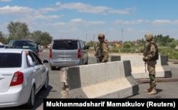 Soldiers guard a road during a government-organized press visit in Nukus on July 6, 2022.