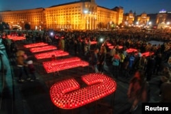 People light candles at Independence Square in Kyiv to form the words "Glory to Ukraine, glory to the Heroes!" during a rally to show support for servicemen on the front line in eastern Ukraine in 2014.