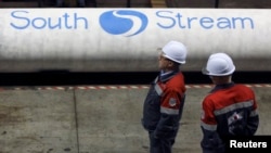 Employees stand near pipes made for the South Stream pipeline at a metal works in the Nizhny Novgorod region.