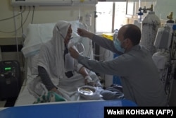 A family member feeds a COVID-19 patient in the intensive care unit of the Muhammed Ali Jinnah hospital in Kabul on June 8.