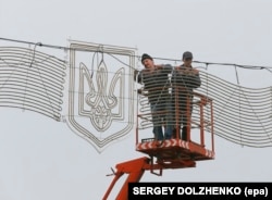 Workers installing a decorative trident in Kyiv in 2014.