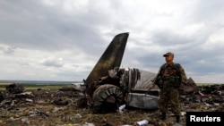 An armed pro-Russian separatist stands guard at the site of the crash of the Il-76 Ukrainian army transport plane in Luhansk on June 14. 