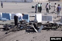 Police inspect the wreckage of the car bomb.