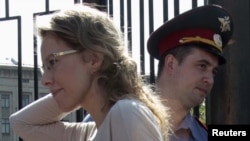 Russian opposition figure and TV host Ksenia Sobchak (left) arrives for questioning at the Russian Investigative Committee on June 15.