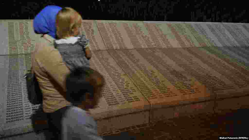 A woman and her children pass in front of the Memorial Center in Potocari that lists more than 7,000 victims of the Srebrenica massacre, deemed an act of genocide by two international courts.