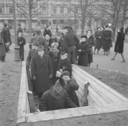 A woman weeps as Helsinki residents file into a bomb shelter.