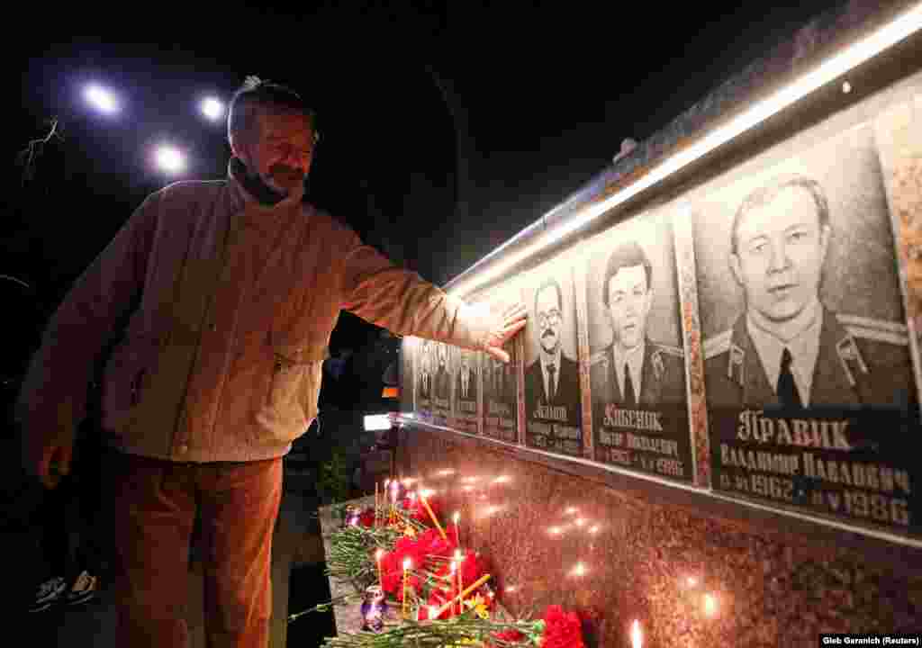 At a monument in Slavutych, a man remembers firefighters who died after the Chernobyl nuclear disaster.