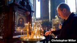 A man lights candles inside St. Volodymyr’s Cathedral in Kyiv.