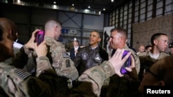 Soldiers take photos as U.S. President Barack Obama (center) shakes hands with troops after delivering remarks at Bagram Air Base near Kabul on May 25.