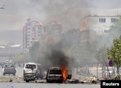 A vehicle is seen on fire after a blast near the Afghan parliament