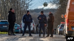 Hungarian police officers close the road near the crash site where a vehicle taking part in the Esztergom Nyerges Rally veered off the road on March 24. 