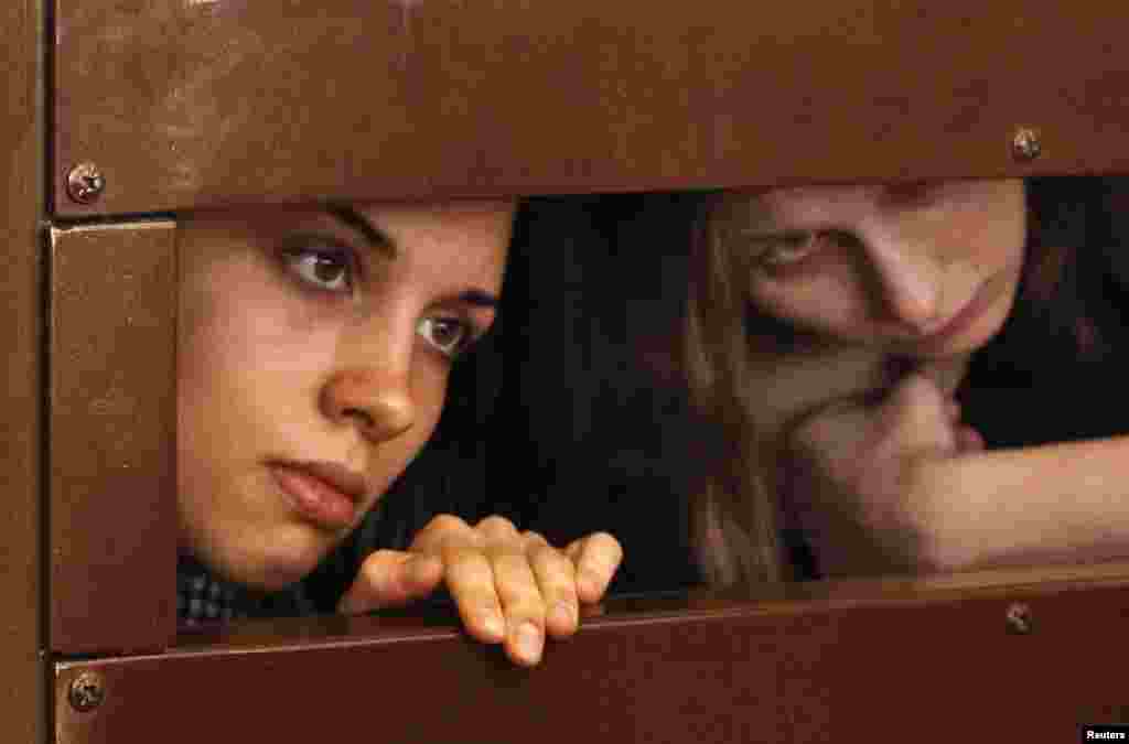 Nadezhda Tolokonnikova (left) and Maria Alyokhina look out from the defendant&#39;s cell in a Moscow courtroom on July 30.