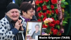 Relatives of the Kerch school-attack victims grieve at a ceremony to pay their last respects in the city center on October 19.