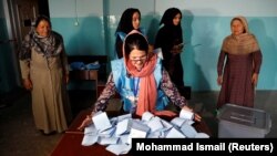 An Afghan election commission worker prepares ballot papers for counting in Kabul.