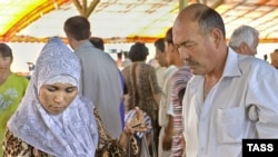 A woman in a hijab shops at a Tashkent market