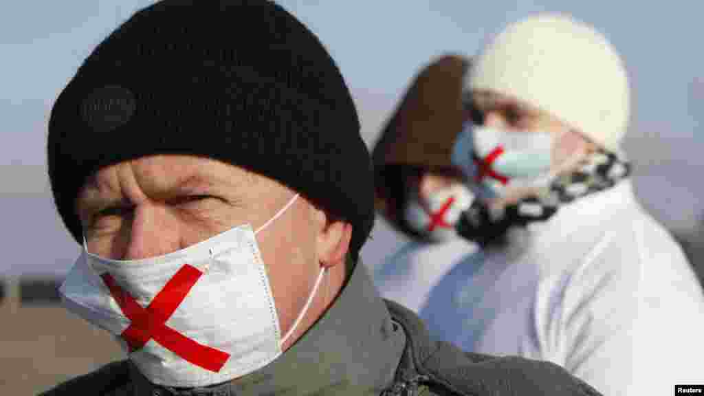 Demonstrators wearing masks take part in the protest against recent parliamentary election results in the southern Russian city of Stavropol.