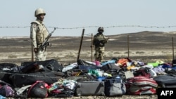 Egyptian Army soldiers stand guard next to the luggage and belongings of passengers from the Russian airliner piled up at the site of the crash in Wadi el-Zolmat, a mountainous area on the Sinai Peninsula.