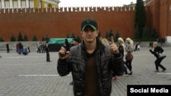 A man identified as Tajik Alan Chekranov holding a pistol and extending one finger -- a common sign used by Islamist militants to mean "one," an attestation of belief in tawhid, or monotheism -- at Red Square in Moscow, possibly in 2012.