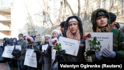 People hold posters with names of the people killed in the Ukraine International Airlines plane that was shot down in Iran in January during a commemoration ceremony in front of the Iranian Embassy in Kyiv on February 17.