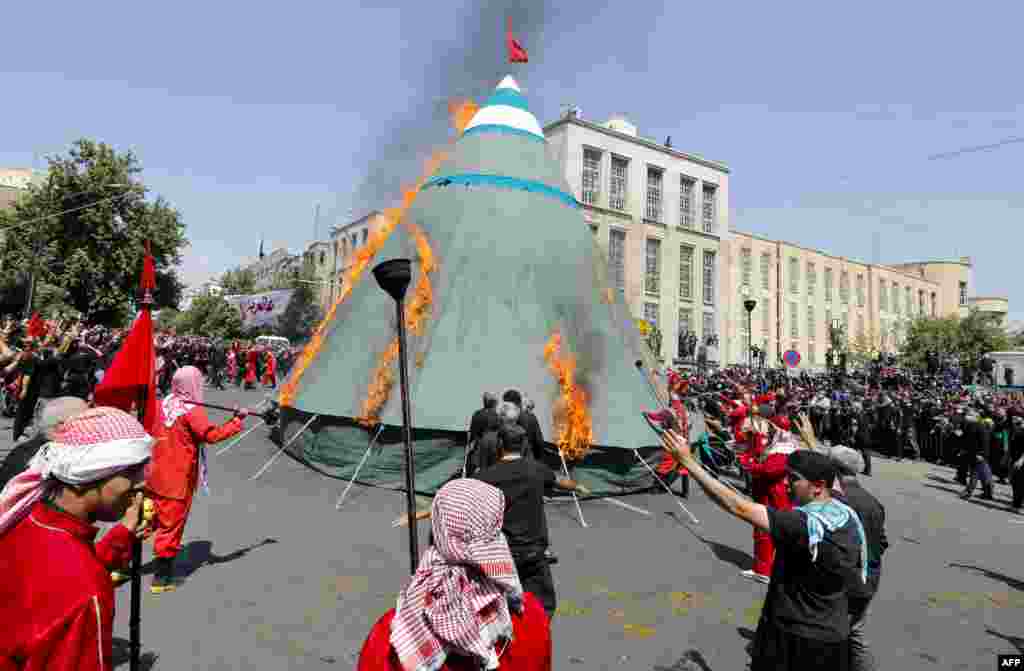 Iranian and Iraqi Shi&#39;ite Muslims burn a tent in Tehran on August 30 during the reenactment of the battle in Karbala in the year 680 that honors the martyrdom of Imam Hussein, the grandson of the Prophet Muhammad.