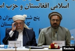 Mohammad Amin Karim (right), a representative of Gulbuddin Hekmatyar, and Sayed Ahmad Gilani, the head of the government's High Peace Council, speak after signing a peace deal in Kabul on September 22.