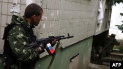 Pro-Russia militants fire from a residential building at Ukrainian border guards defending the Federal Border Headquarters in Luhansk on June 2.