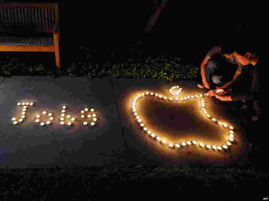 Chinese exchange students use candles to create the Apple logo and spell out the late CEO&#39;s name in a tribute in Cupertino, California, on October 5.