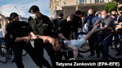 Police officers detain a protester during a rally in Minsk on June 19.